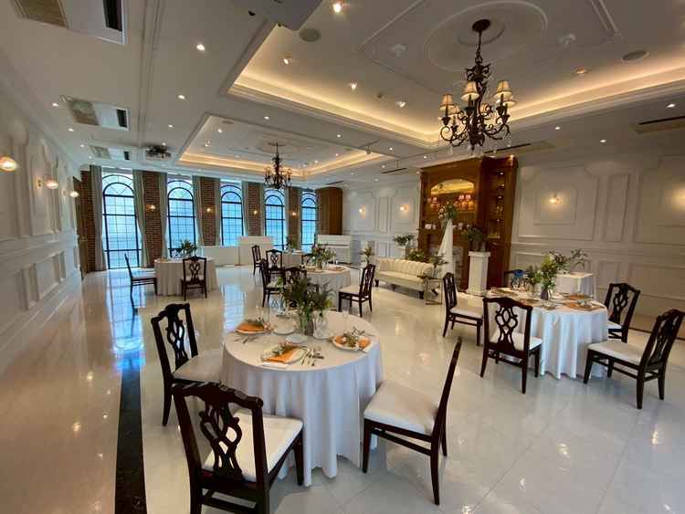 挙式会場から１階下がるとすぐ宴会場。大きな窓を開けてテラスとつなぐこともできる。