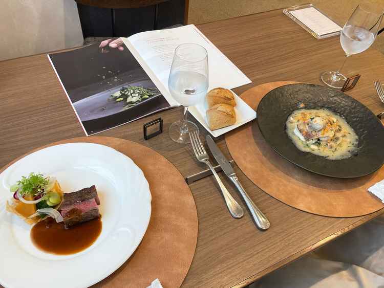 試食時の全体写真「2人でメインのお肉料理と魚料理の2プレートにパン２つ」