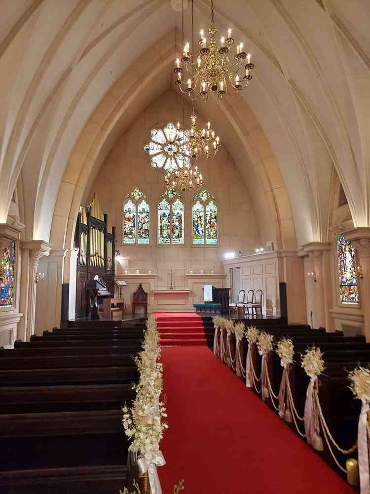 ステンドグラスがあるチャペルの写真。天井が高く結婚式らしさを感じた。