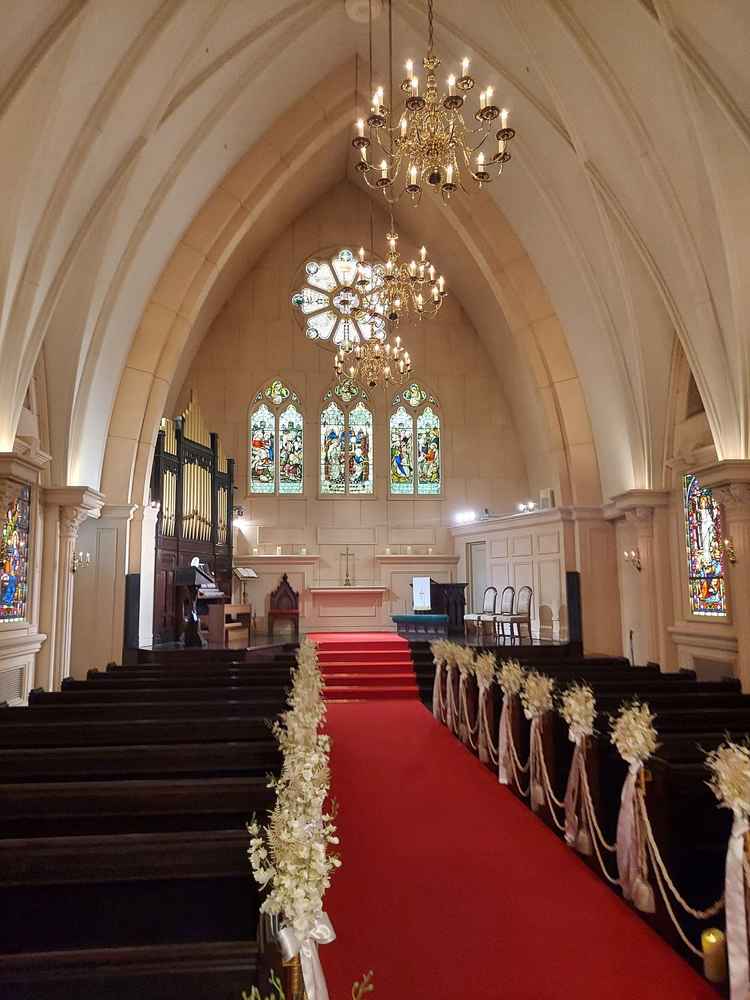 ステンドグラスがあるチャペルの写真。天井が高く結婚式らしさを感じた。