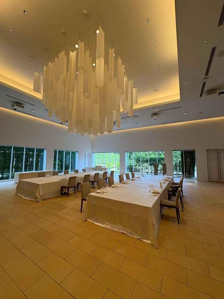 白が基調の披露宴会場の写真です。広さ十分で4面スクリーンのためどの席からでもムービーが見やすかった。