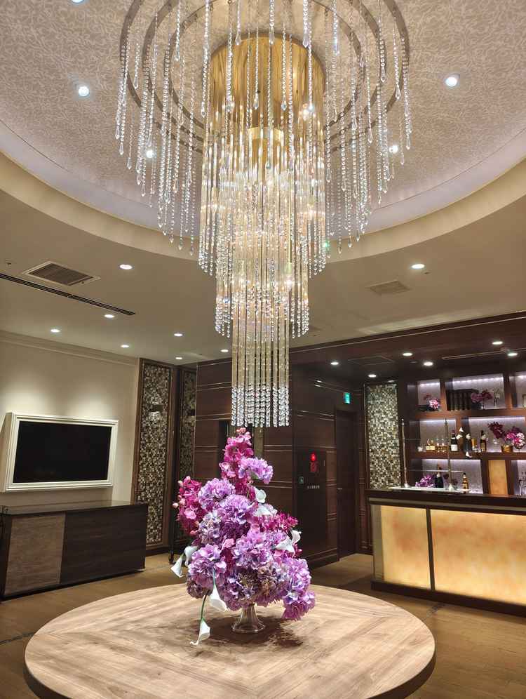 披露宴会場のロビーは、シャンデリアや装花が華やかで、ゲストにゆったり過ごしてもらえそうな雰囲気でした