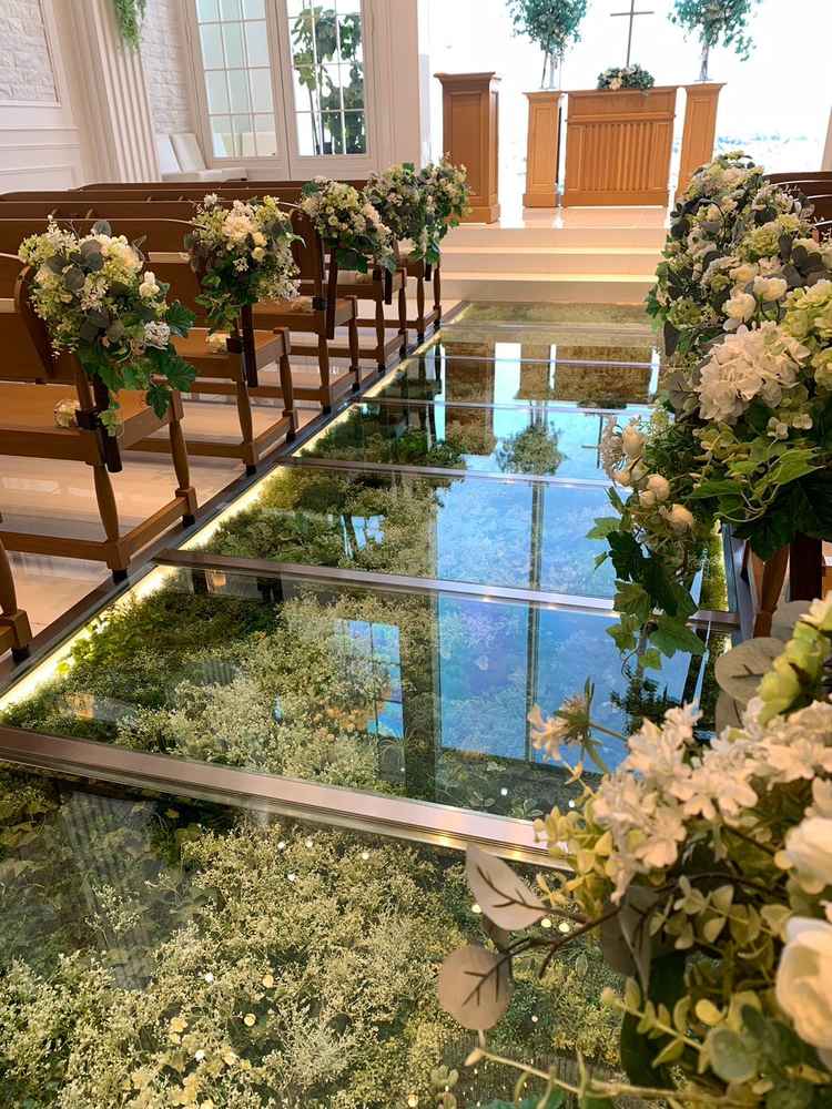 チャペルのバージンロードがガラスになっていて、緑の植物が飾られていて、自然も感じる空間になっていた。