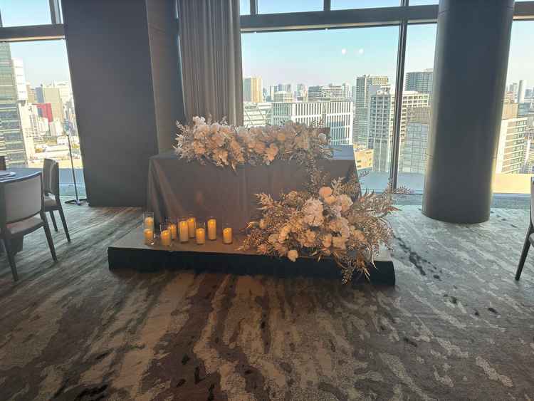 大きな窓の前の新郎新婦席から品川の街並みが見え、白い装花とキャンドルにも高級感がありました。
