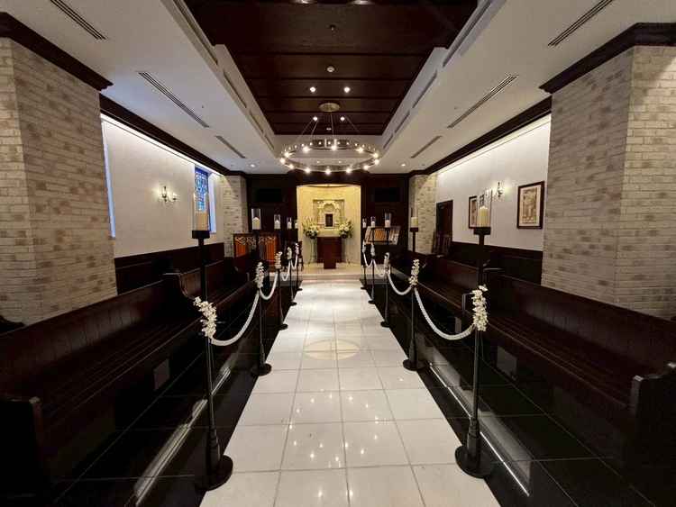 落ち着いた雰囲気と重厚感があり、厳かな空気が漂うチャペル。レンガ壁と木のベンチが温かみを感じさせる。