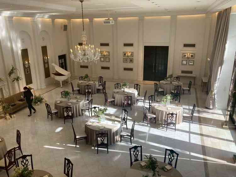 白を基調とした披露宴会場。ナチュラルにかわいい雰囲気だが、花の色や装飾によって雰囲気は変えられそう。