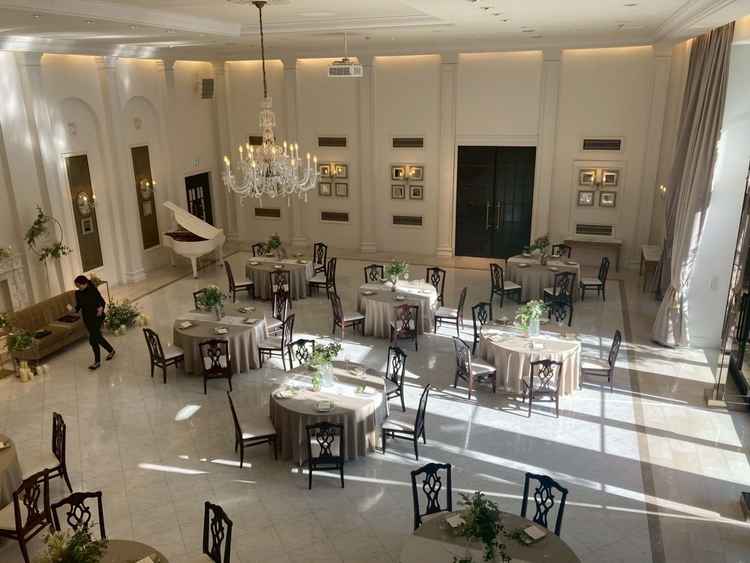 白を基調とした披露宴会場。ナチュラルにかわいい雰囲気だが、花の色や装飾によって雰囲気は変えられそう。