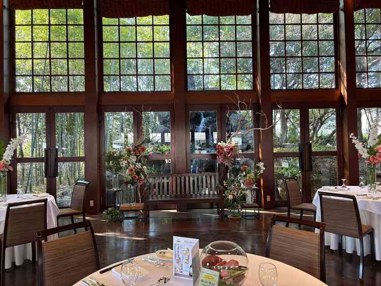 披露宴会場。新郎新婦が着席する奥には滝が見えます。3面ガラス張りで外が見え、滝の音が常に響いています