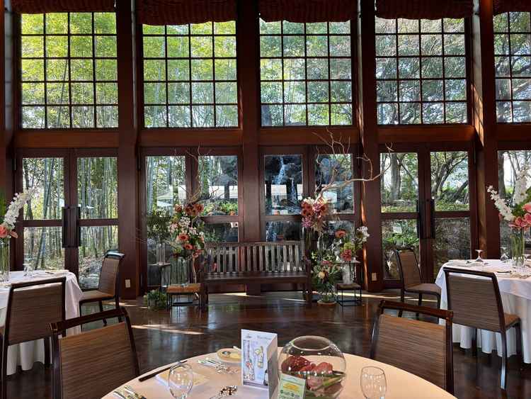 披露宴会場。新郎新婦が着席する奥には滝が見えます。3面ガラス張りで外が見え、滝の音が常に響いています