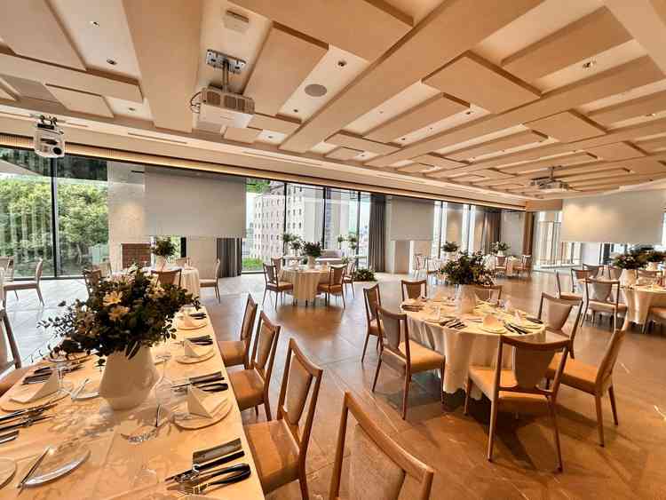 【披露宴会場】暖かな色でアットホームさを感じる。適度な広さと外の景色も十分に見える。スクリーンは3つ