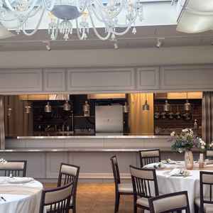 披露宴会場の写真です。白が基調でオープンキッチンもあり、さまざまな演出が楽しめると思いました。