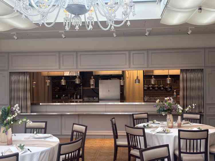 披露宴会場の写真です。白が基調でオープンキッチンもあり、さまざまな演出が楽しめると思いました。