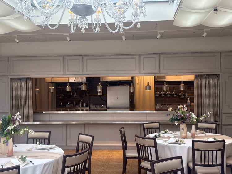 披露宴会場の写真です。白が基調でオープンキッチンもあり、さまざまな演出が楽しめると思いました。