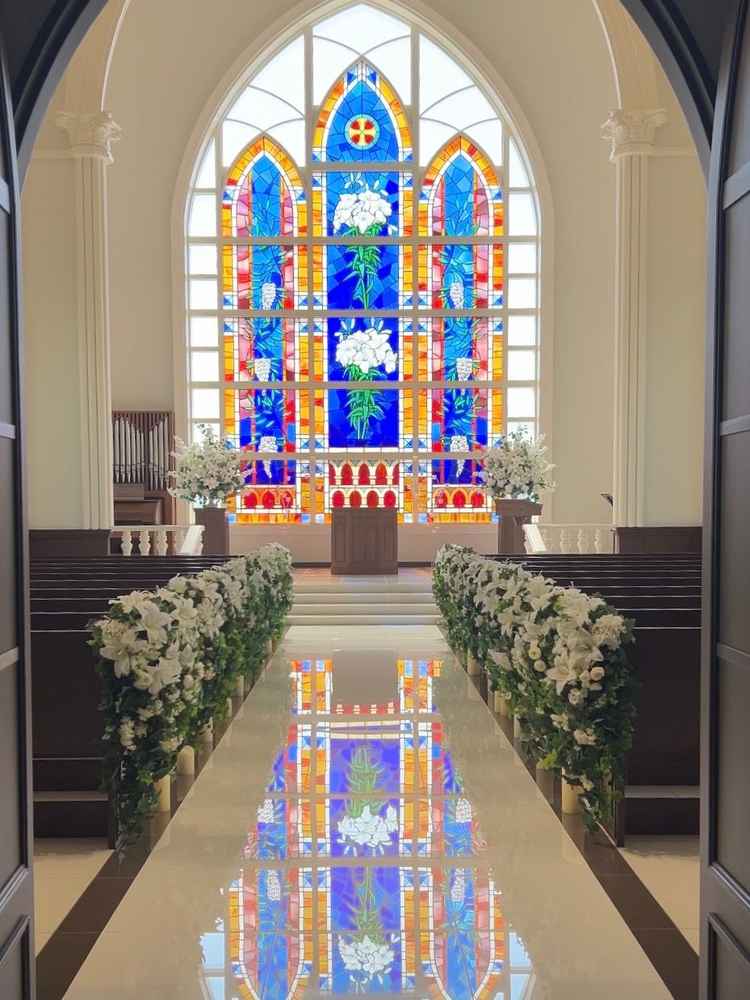 大理石のバージンロードにはあえてカーペットを敷かず、ステンドグラスが反射するようにされていました。