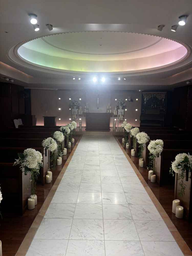 後方からのチャペルの様子。ゆらめくキャンドルと白いお花の飾りが可愛らしいです。