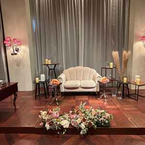 披露宴会場「ルビーノ」の高砂。木目の会場の雰囲気とソファ席とお花がマッチしていた。