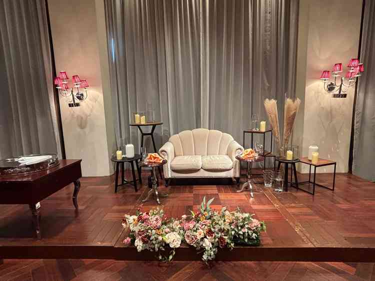 披露宴会場「ルビーノ」の高砂。木目の会場の雰囲気とソファ席とお花がマッチしていた。