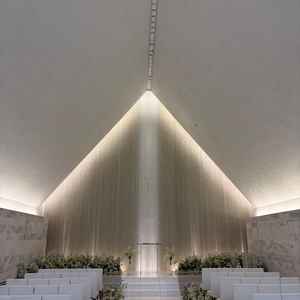 神聖な挙式会場。座席はよくあるベンチではなく、個人のスペースが区切られていて工夫を感じる。白基調。