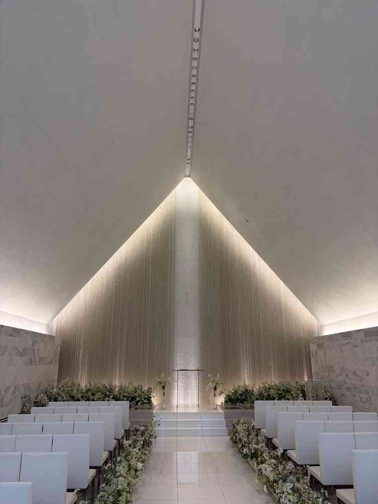 神聖な挙式会場。座席はよくあるベンチではなく、個人のスペースが区切られていて工夫を感じる。白基調。