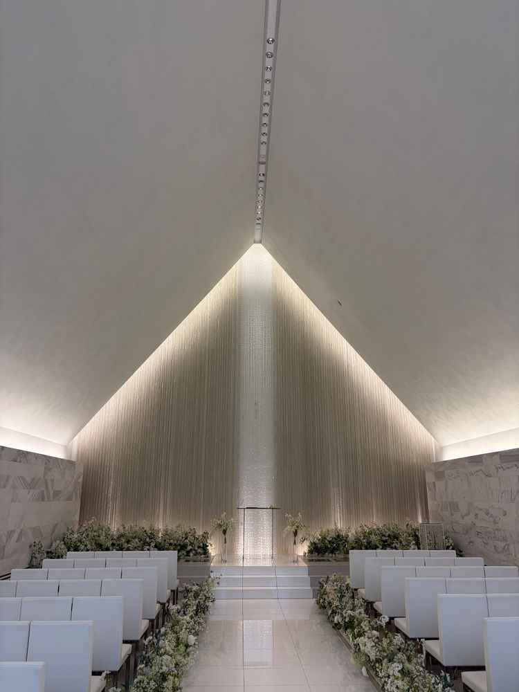 神聖な挙式会場。座席はよくあるベンチではなく、個人のスペースが区切られていて工夫を感じる。白基調。