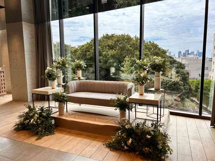 【披露宴会場の新郎新婦席背景】大学の緑が映り自然を感じる。ただ角度を変えるとJREASTホテルあり。