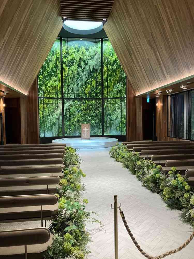 挙式会場。天井が高く木目調でグリーンが映える式場です。参列者の座席も座りごごちがよかったです。
