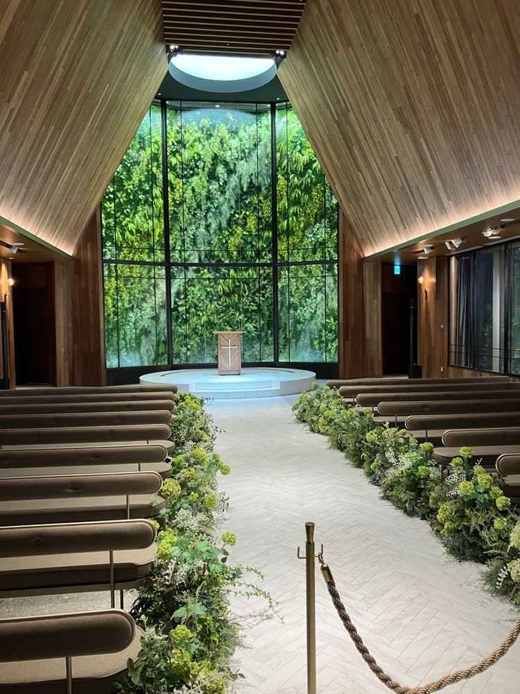 挙式会場。天井が高く木目調でグリーンが映える式場です。参列者の座席も座りごごちがよかったです。