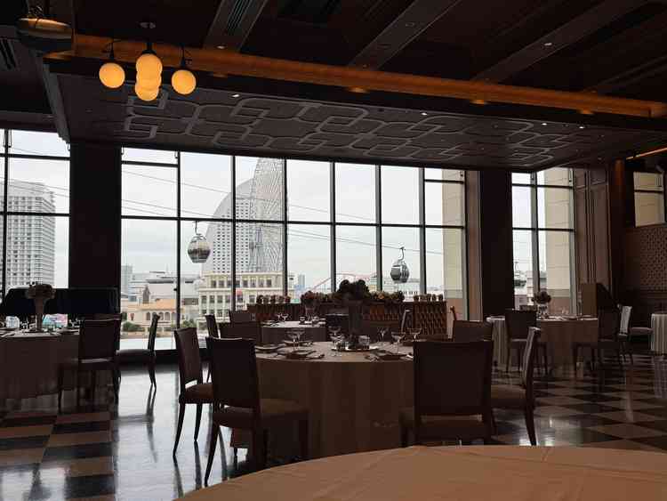 落ち着いたホテルライクなデザインの披露宴会場。こちらも背景にはみなとみらいが一望できるガラス窓。