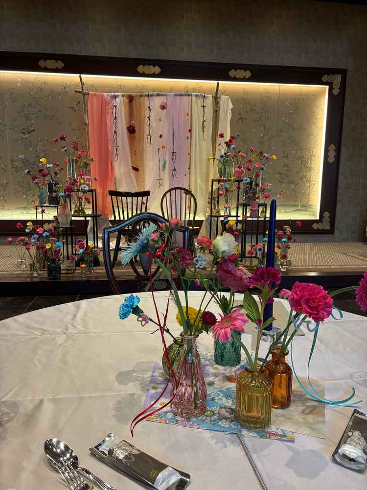 披露宴会場。この日はカラフルな花が各机、新郎新婦の椅子の所に飾ってありました。
