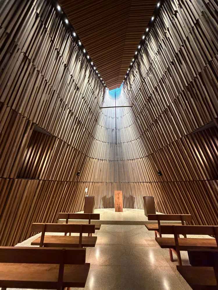 チャペルの天井高は16メートルと高く、自然光が少し入る丁度良い明るさ。壁の木の形や大きさは全て異なる