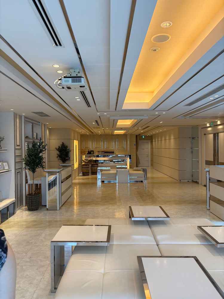 ゲスト待合室の写真。広々としており、白基調のスタイリッシュなデザイン。奥にはバーカウンターもあり。