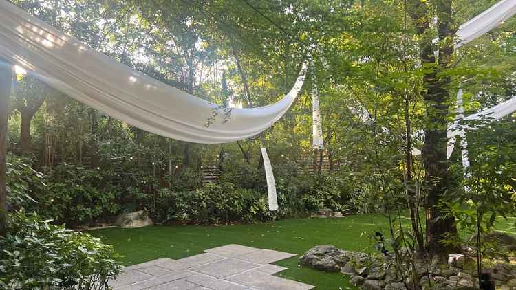 披露宴会場の新郎新婦が座る席の後ろの窓から出入りできるお庭はとても広く理想とするものでした。