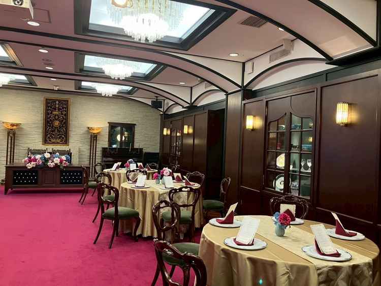 披露宴会場の「結」はクラシックな雰囲気で、壁のショーケースにはアンティークな展示品があり上質な演出。