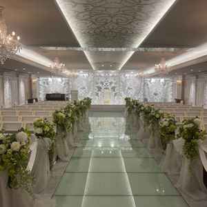 挙式会場。ガラスのバージンロードと白い装飾が美しい、華やかな空間でした。