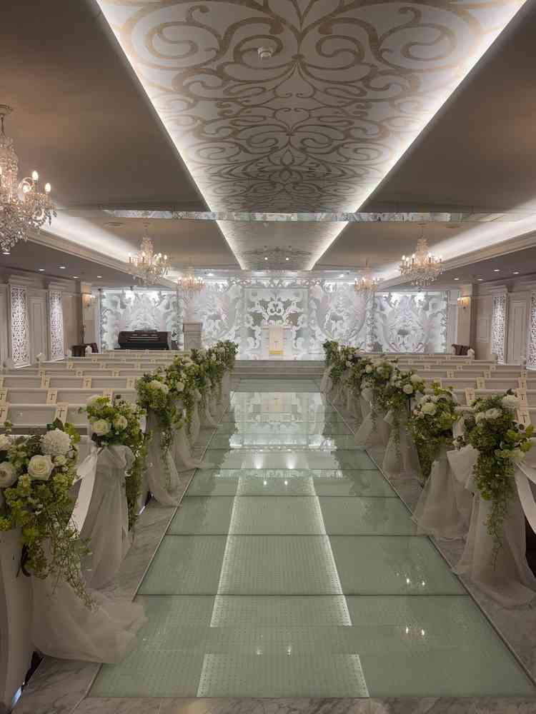 挙式会場。ガラスのバージンロードと白い装飾が美しい、華やかな空間でした。