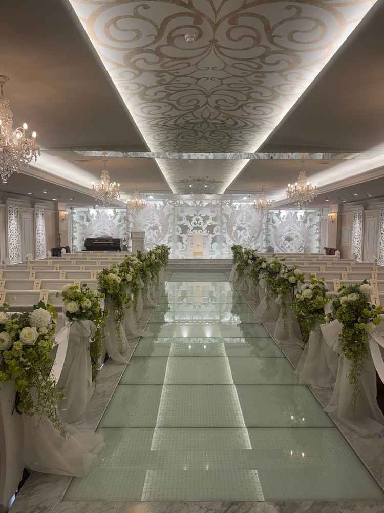 挙式会場。ガラスのバージンロードと白い装飾が美しい、華やかな空間でした。