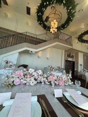 ゲストと距離が近く、ピンクの花が彩る魅力的な披露宴会場。雨の日も光が差し込み景色も美しいそうだ。