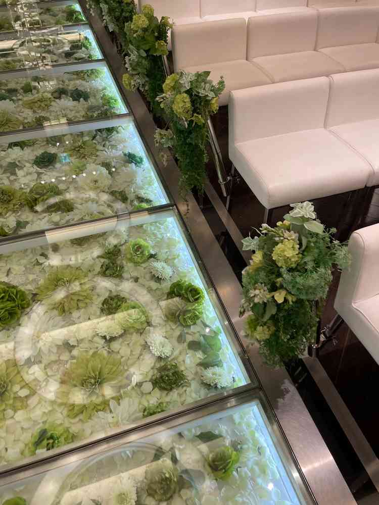 バージンロードがガラス張りでグリーンのお花たち