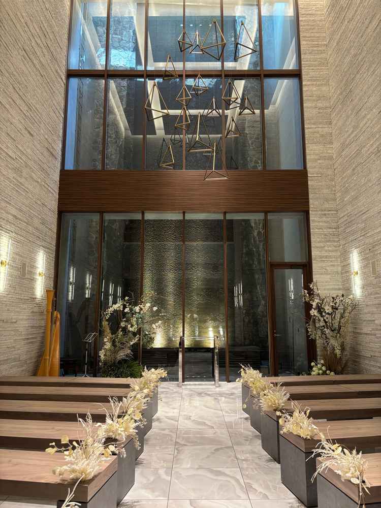 挙式会場は天井が高く開放感があった。石畳の壁と正面の滝も圧巻だった。