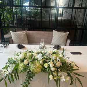 披露宴会場の高砂。テーブルスタイルで、テーブル周りの花は自分好みにカスタマイズ可能。