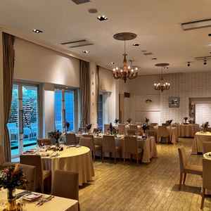 白を基調とする披露宴会場の全体の写真。シャンデリアがウッド調で魅力的だった。