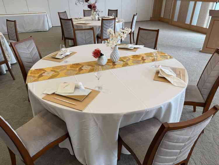 披露宴会場のテーブルです。ランナーは帯を使用しています。