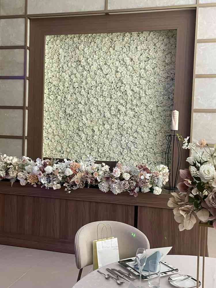 披露宴会場。新郎新婦の後ろにお花が敷き詰められていたのがすてきだった。