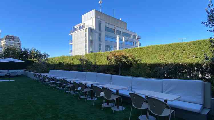 青空の下に広がる開放的なテラススペースで、緑豊かな植栽に囲まれた落ち着きのある空間でした。