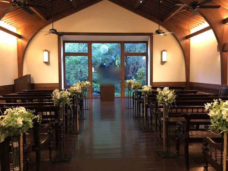 挙式会場。温かな雰囲気で雨でも同じような明るさ、雰囲気とのこと。背景に滝が流れており素敵だった。