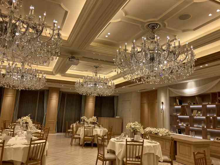 木目調の会場にシャンデリアがとても映えて綺麗。テーブルは小さめで全員と乾杯できるよう設計されている。