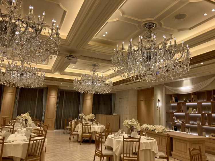 木目調の会場にシャンデリアがとても映えて綺麗。テーブルは小さめで全員と乾杯できるよう設計されている。