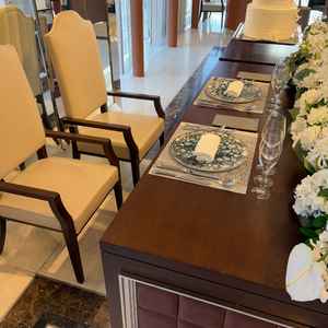 披露宴会場の新郎新婦席。座席含め落ち着いた印象。周りの花はボリュームアップすることも可能。