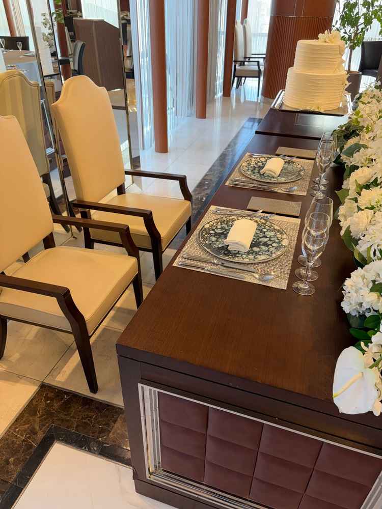 披露宴会場の新郎新婦席。座席含め落ち着いた印象。周りの花はボリュームアップすることも可能。