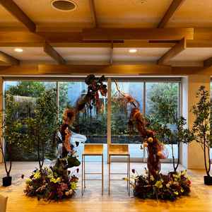 披露宴会場の高砂の写真。後ろのグリーンの背景と相まって、やり過ぎないながらも華やかな印象を得た。